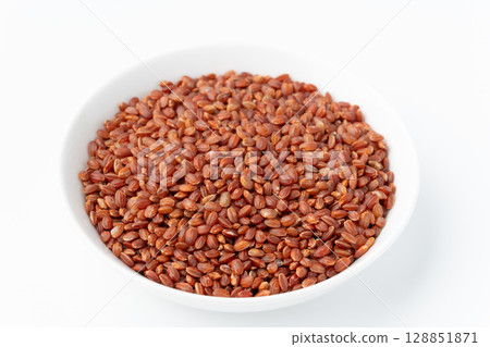 Red rice in a plate on a white background 128851871