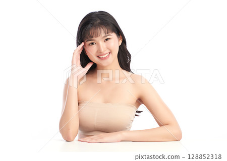 A beautiful young Asian woman with clean, fresh skin against a white background. Skincare, facial treatment, cosmetology, beauty, and spa. An elegant portrait of an Asian woman. A beautiful young Asian woman with clean, fresh skin against a white background. Skincare, facial treatment, cosmetology, beauty, and spa. An elegant portrait of an Asian woman. 128852318