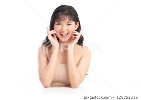 A beautiful young Asian woman with clean, fresh skin against a white background. Skincare, facial treatment, cosmetology, beauty, and spa. An elegant portrait of an Asian woman. 128852319
