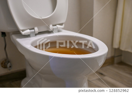 Toilet with discolored water indicating possible plumbing issues in a residential bathroom Toilet with discolored water indicating possible plumbing issues in a residential bathroom 128852962
