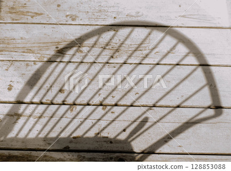 Shadow of a Chair on Rustic Wooden Deck Shadow of a Chair on Rustic Wooden Deck 128853088