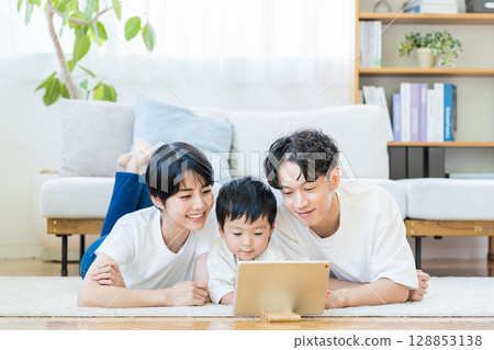 Parents and children looking at a tablet together. 128853138