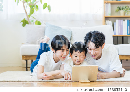 父母和孩子一起看平板電腦。 128853140