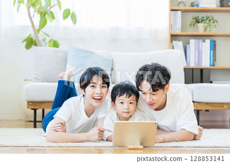 父母和孩子一起看平板電腦。 128853141