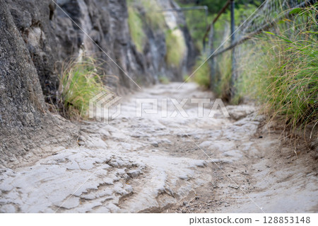 Selective focus on an uneven surface of the hiking trail to the summit of Diamond Head State Monument in Oahu, Hawaii  Selective focus on an uneven surface of the hiking trail to the summit of Diamond Head State Monument in Oahu, Hawaii  128853148