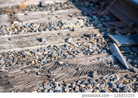 Damaged section of railroad tracks with aged wooden ties 128853155