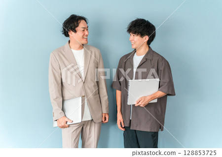 Smiling businessman with a computer (programmer, engineer, system engineer) 128853725