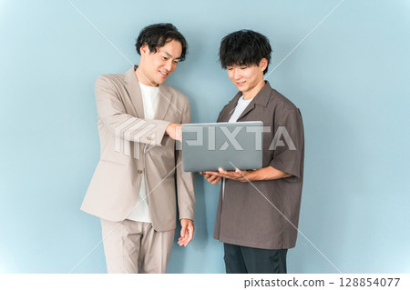 Smiling businessman with a computer (programmer, engineer, system engineer) 128854077