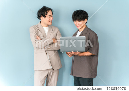 Smiling businessman with a computer (programmer, engineer, system engineer) 128854078