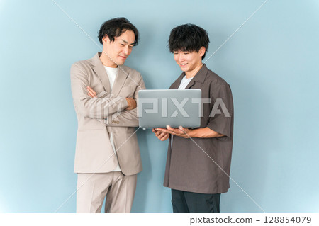 Smiling businessman with a computer (programmer, engineer, system engineer) 128854079