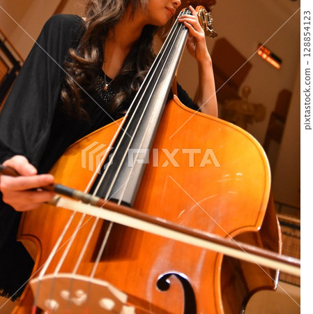 A female player playing the double bass gracefully 128854123