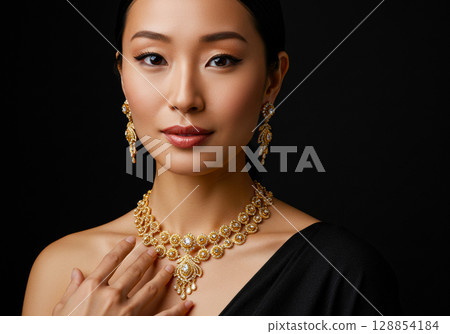 一位女士在黑色背景上擺出佩戴珠寶的姿勢 一位女士在黑色背景上擺出佩戴珠寶的姿勢 128854184