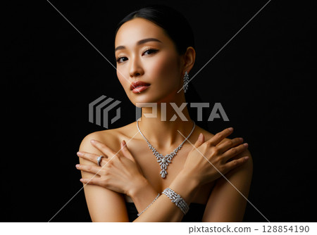 一位女士在黑色背景上擺出佩戴珠寶的姿勢 一位女士在黑色背景上擺出佩戴珠寶的姿勢 128854190