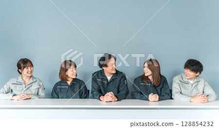 Employees and staff (businessmen and businesswomen) wearing work clothes working at small and medium-sized enterprises such as factories and construction companies. 128854232