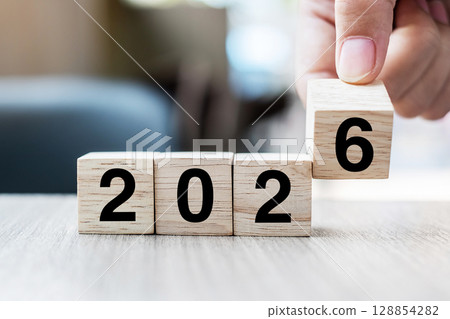 hand flipping block 2025 to 2026 text on table. Resolution, strategy, plan, goal, motivation, reboot, business and New Year holiday concepts 128854282