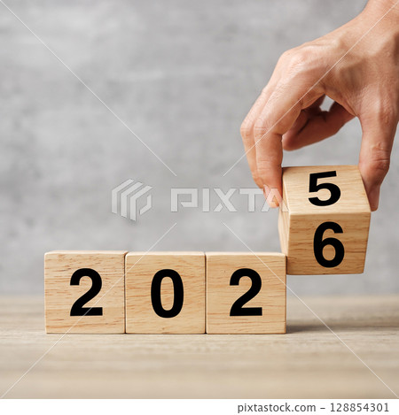 hand flipping block 2025 to 2026  text on table. Resolution, strategy, plan, goal, motivation, reboot, business and New Year holiday concepts 128854301