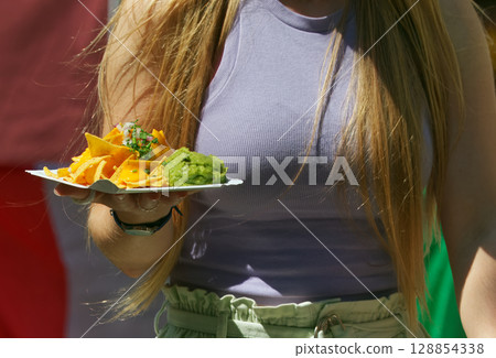 Trendy street food in young womans hand Trendy street food in young womans hand 128854338