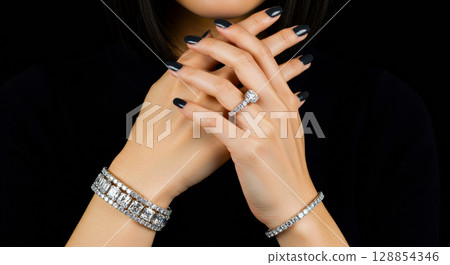 Woman's hand pose with jewelry on black background 128854346