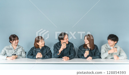 穿著工作服的女人和男人在辦公室休息區喝咖啡 128854393