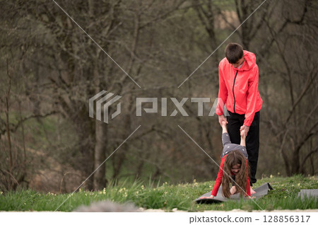 Joyful childhood moments captured in a playful outdoor environment during spring with friends engaging in fun activities and laughter amidst nature's beauty 128856317