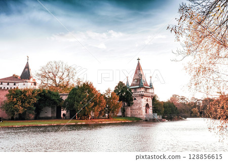 Autumn Laxenburg park with medieval Franzensburg castle on lake at sunset, Lower Austria 128856615
