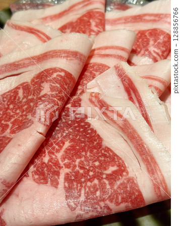 Closeup of thinly sliced raw beef, ready to be used in shabu-shabu, sukiyaki or hot pot. Closeup of thinly sliced raw beef, ready to be used in shabu-shabu, sukiyaki or hot pot. 128856766