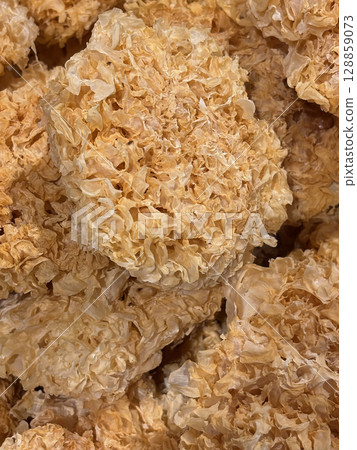 Closeup of dehydrated snow fungus. Also known as white fungus, silver ear mushroom, or snow ear, it is a type of edible fungus widely used in Chinese cuisine and traditional medicine. 128859073
