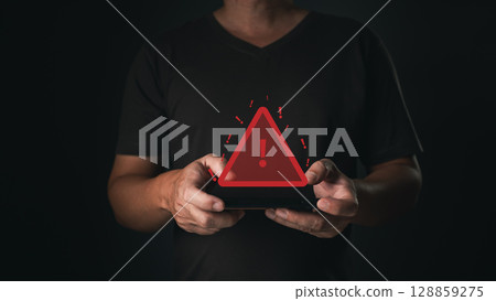 A smartphone user receives a caution notification as a glowing red warning symbol appears, indicating a potential error or alert in the digital system. 128859275