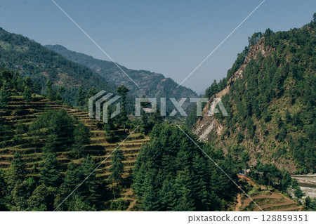 Terraced farming in Nepal. Village on a terraced hill during Annapurna Circuit Trek in Himalayas, Annapurna Conservation Area, Nepal. Rise fields. Agricultural concept Terraced farming in Nepal. Village on a terraced hill during Annapurna Circuit Trek in Himalayas, Annapurna Conservation Area, Nepal. Rise fields. Agricultural concept 128859351