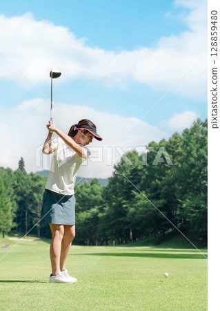 A golfer's woman playing golf on a golf course (tee shot/golf competition) A golfer's woman playing golf on a golf course (tee shot/golf competition) 128859480