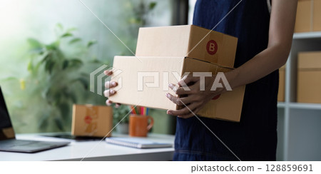 Young Entrepreneur Managing Startup SME Business Operations with Focus on E-commerce and Online Sales in a Modern Workspace 128859691