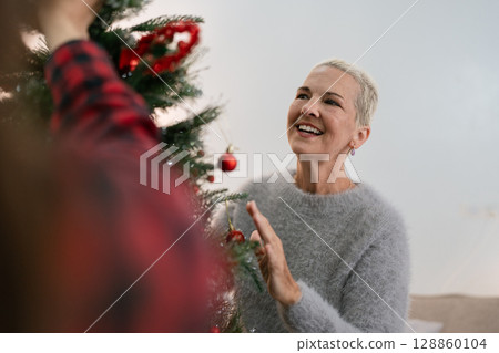 Woman decorate for Christmas at home. Family celebrate and Happy new year at home Woman decorate for Christmas at home. Family celebrate and Happy new year at home 128860104