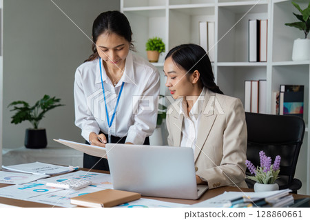 Professional Business Meeting in Modern Office with Diverse Team Collaborating on Project Strategies and Analyzing Financial Data 128860661