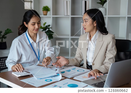 Professional Business Meeting in Modern Office with Diverse Team Analyzing Financial Reports and Discussing Strategies 128860662