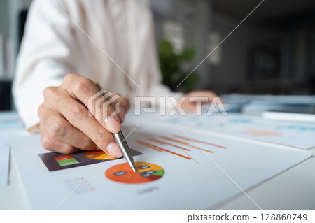 Business Professional Analyzing Financial Data with Charts and Graphs in a Modern Office Setting 128860749