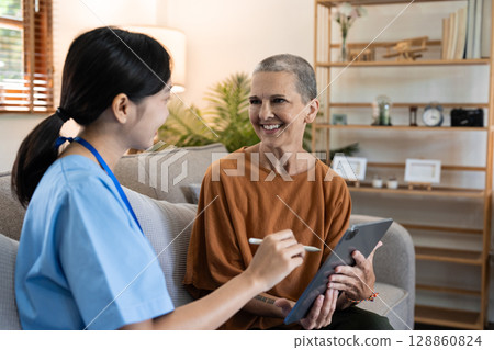 Healthcare Professional Visiting Senior at Home, Providing Medical Consultation and Support in a Comfortable Living Room Setting Healthcare Professional Visiting Senior at Home, Providing Medical Consultation and Support in a Comfortable Living Room Setting 128860824