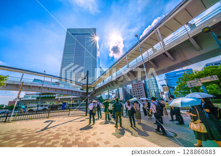 Yokohama cityscape in Japan: Morning commute to work. In the background is Yokohama City Hall in front of Sakuragicho Station. 128860883