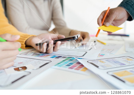 Collaborative UX UI Design Process with Team Working on Mobile App Prototypes and Wireframes Collaborative UX UI Design Process with Team Working on Mobile App Prototypes and Wireframes 128861070