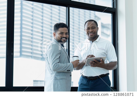 Business Professionals Collaborating in Modern Office with Digital Tablet and Coffee Business Professionals Collaborating in Modern Office with Digital Tablet and Coffee 128861071