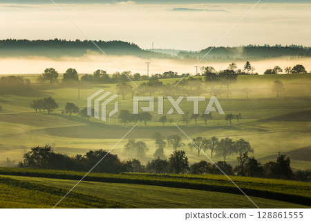 Misty autumn morning over rolling green hills, Hegau, Baden-Wuerttemberg, Germany Misty autumn morning over rolling green hills, Hegau, Baden-Wuerttemberg, Germany 128861555