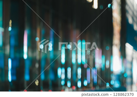 Blurred image of city street at night with glowing bokeh lights abstract background 128862370