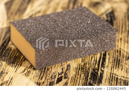 sandpaper for polishing of wooden surfaces, wooden board made of pine planks for polishing with sandpaper on the construction site 128862445