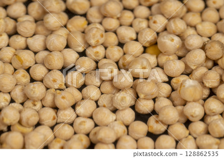 yellow chickpeas floating in the water, poured into the water a large number of chickpeas, closeup yellow chickpeas floating in the water, poured into the water a large number of chickpeas, closeup 128862535
