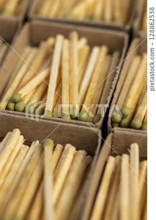 a lot of matches with head in matchbox, the green head of a wooden match laid out in cardboard boxes, closeup 128862538