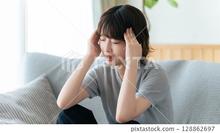 一個憂心忡忡的女人抱著頭 一個憂心忡忡的女人抱著頭 128862697