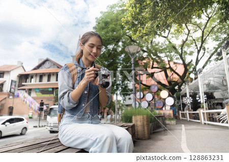 Enthusiastic photographer reviewing shots in city 128863231