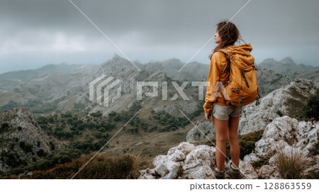A young woman with yellow backpack at the mountain 128863559