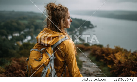 A young woman with yellow backpack at the mountain A young woman with yellow backpack at the mountain 128863578