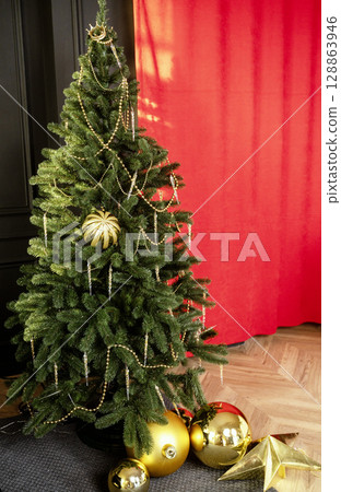 The Christmas tree stands on a red background. 128863946