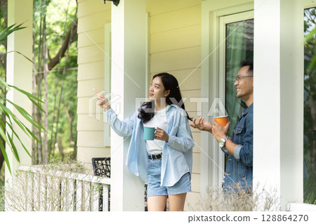 Exploring nature. Young couple enjoying a scenic view from their porch. 128864270